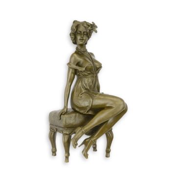A BRONZE SCULPTURE OF A WOMAN ON A STOOL