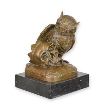 A BRONZE SCULPTURE OF AN OWL WITH A SKULL