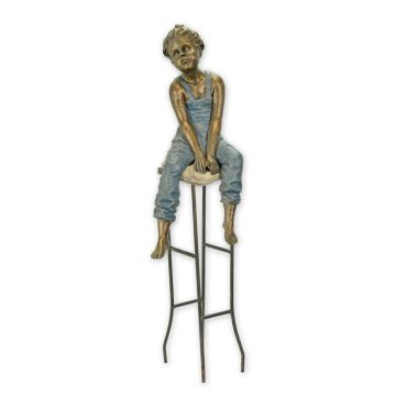 A RESIN SCULPTURE OF A LITTLE BOY ON STOOL