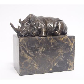 A BRONZE SCULPTURE OF A LYING RHINOCEROS