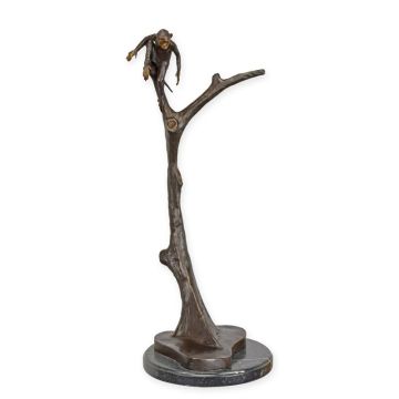 A BRONZE SCULPTURE OF A MONKEY IN A TREE
