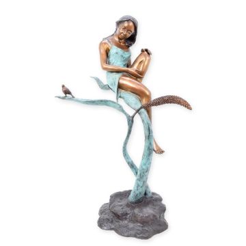 A BRONZE SCULPTURE OF A GIRL SITTING ON A LEAF